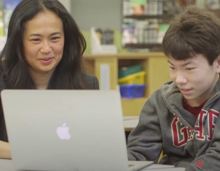 Teacher and student looking at a computer.