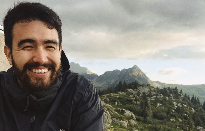 Portrait photo of Nick in front of a green mountainside